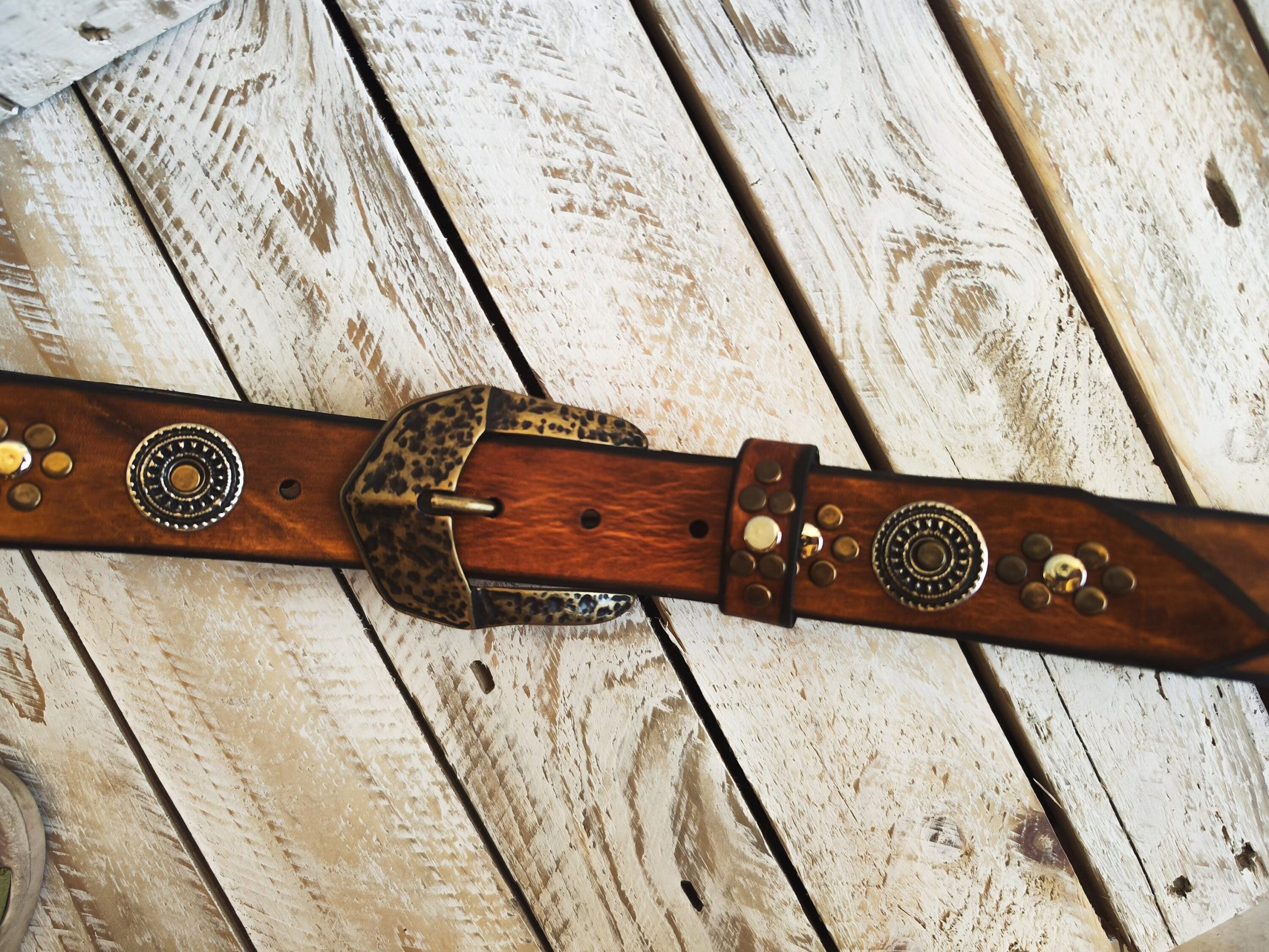 handcrafted brown leather belt with ishaor's unique design: light brown belt with gold and silver rivets and silver coin accents